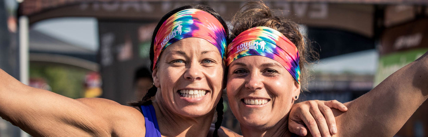 Two women wearing Tough Mudder by Junk headbands at a Tough Mudder event