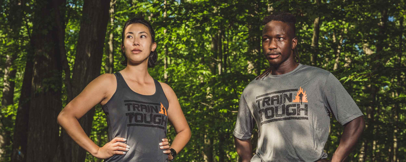 A man and women standing in the woods wearing Tough Mudder brand grey t-shirts